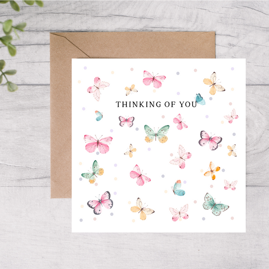 Greeting card with colorful butterflies and 'Thinking of You' text on a white background