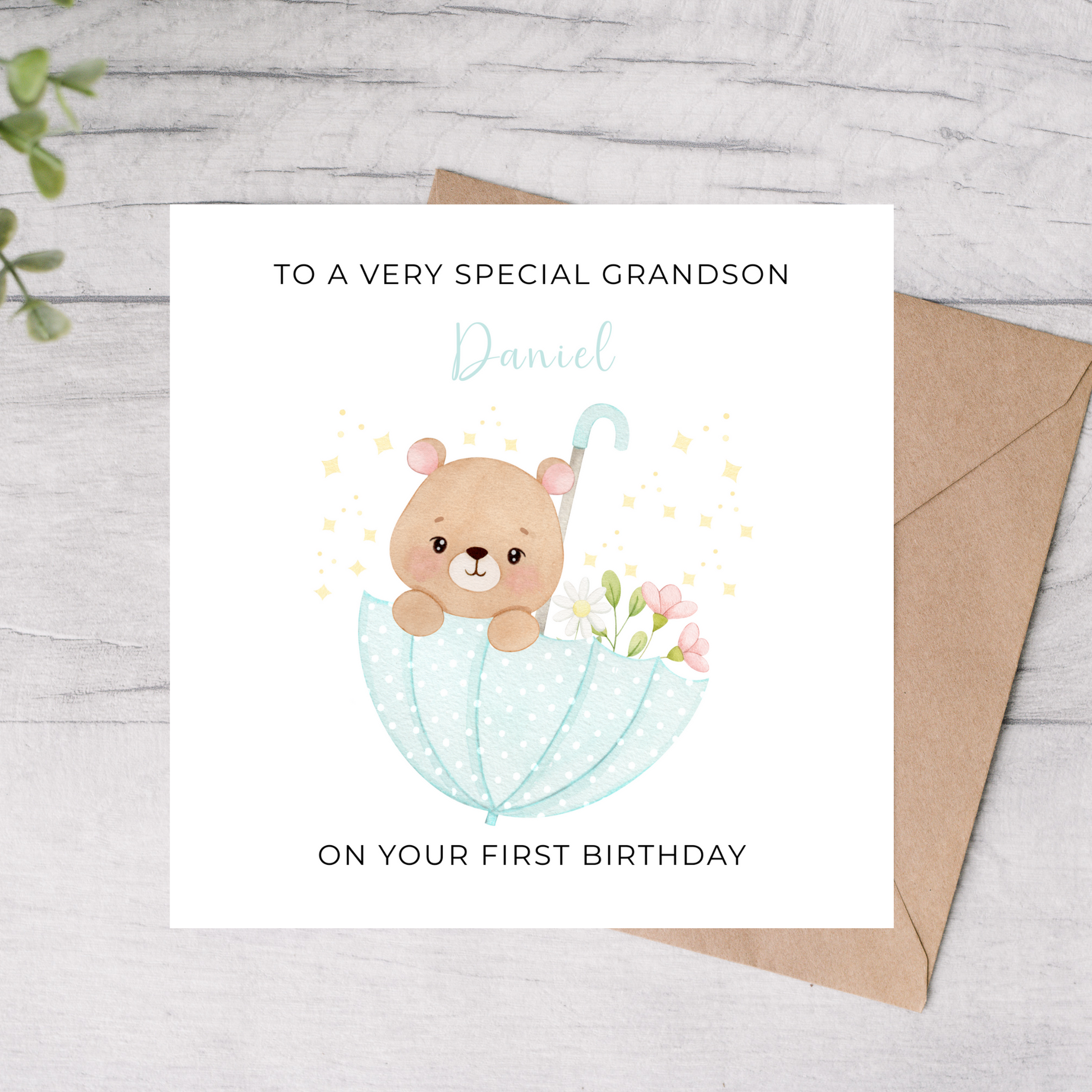 Birthday card for a special grandson with a bear and umbrella illustration, on a wooden surface.